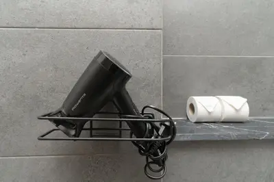 a black hair dryer on a shelf in a bathroom at Gueliz - Pool & Jacuzzi - Luxury Residence in Marrakech