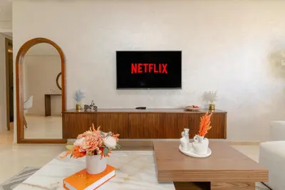 a living room with a tv on a wall at Gueliz - Pool & Jacuzzi - Luxury Residence in Marrakech