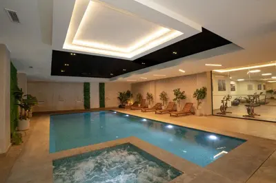 a large swimming pool in a building with a skylight at Gueliz - Pool & Jacuzzi - Luxury Residence in Marrakech