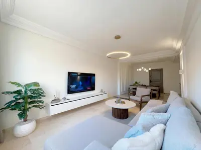 a living room with a blue couch and a tv at Modern & Luxurious Apartment, Terrace with panoramic view of Gueliz in Marrakech