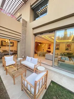 a patio with couches and tables in a building at Villa luxe, tranquillité aux portes de Marrakech in Marrakech