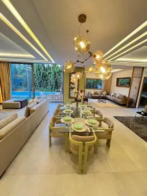 a large living room with a table and chairs at Villa luxe, tranquillité aux portes de Marrakech in Marrakech