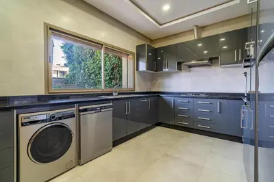 a kitchen with a washer and dryer in it at Villa luxe, tranquillité aux portes de Marrakech in Marrakech