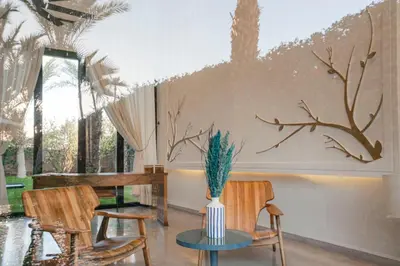 a room with two chairs and a table with a plant on it at Resort Batoul nor marrakech in Marrakech