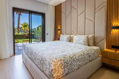 a bedroom with a large bed and a large window at Marrakech golf Prestigia Jade in Marrakech