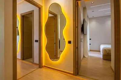 a hallway with a yellow wall with a mirror at Marrakech golf Prestigia Jade in Marrakech