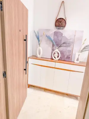 a room with a cabinet with vases and a clock at Studio haut standing in Marrakech