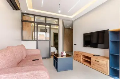 a living room with a couch and a flat screen tv at Studio Nahellan in Marrakech
