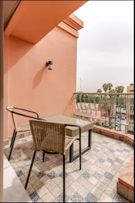 a table and a chair on a balcony at Studio Nahellan in Marrakech