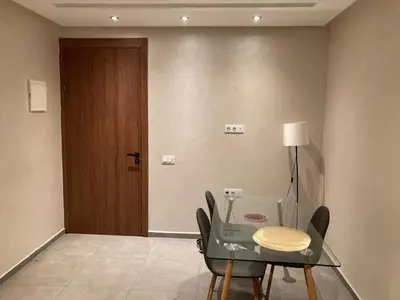 a dining room with a table and chairs and a door at Perfect condo for tourists in semlalia in Marrakech
