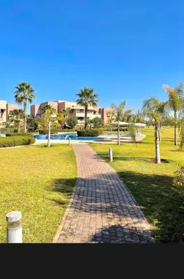 a brick path in a park with palm trees at 2 chambre Prestigia Jade golf city in Marrakech