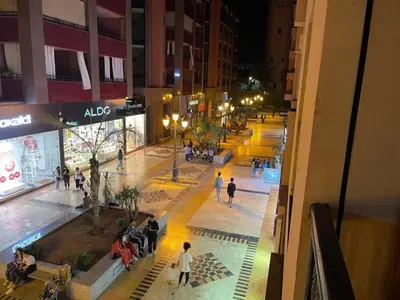 a group of people walking in a city at night at Central Gueliz 2Bedroom Apartment in Marrakech