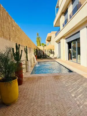 a swimming pool in front of a building with plants at Villa Familiale - Idéale pour Groupe jusqu'à 10 Personnes in Marrakech