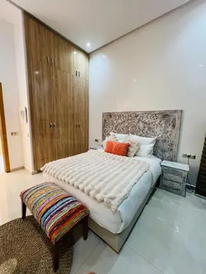 a bedroom with a large bed and a wooden cabinet at Villa Familiale - Idéale pour Groupe jusqu'à 10 Personnes in Marrakech