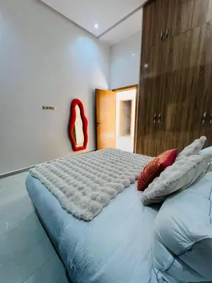 a large bed in a room with a red chair at Villa Familiale - Idéale pour Groupe jusqu'à 10 Personnes in Marrakech