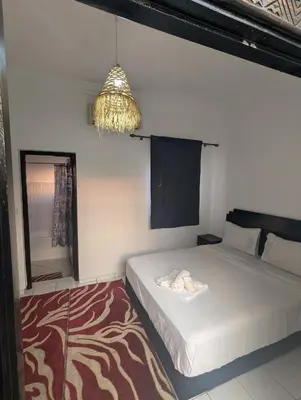 a bedroom with a bed and a mirror and a chandelier at Riad absar in Marrakech