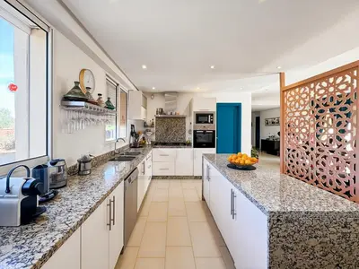 a kitchen with white cabinets and granite counter tops at Exceptional Villa Private Pool - Ourika Road in Marrakech