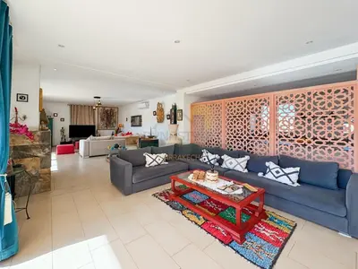 a living room with a blue couch and a table at Exceptional Villa Private Pool - Ourika Road in Marrakech