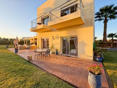 a house with a patio with a table and a balcony at Exceptional Villa Private Pool - Ourika Road in Marrakech