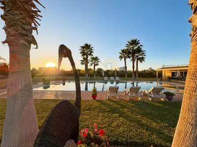 a view of a pool with palm trees and the sunset at Exceptional Villa Private Pool - Ourika Road in Marrakech