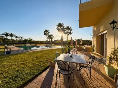 a man standing on a patio with a table and chairs at Exceptional Villa Private Pool - Ourika Road in Marrakech