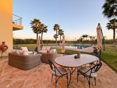 a patio with a table and chairs and a pool at Exceptional Villa Private Pool - Ourika Road in Marrakech