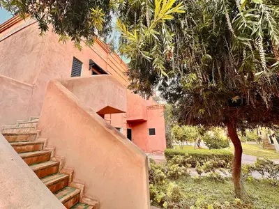 a staircase in front of a building with a tree at Elegant Cocoon 2 Bedrooms, Pool & Rooftop in Marrakech