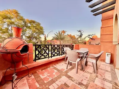 a patio with a table and chairs on a balcony at Elegant Cocoon 2 Bedrooms, Pool & Rooftop in Marrakech