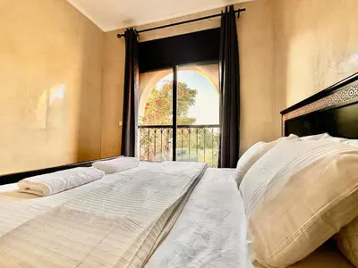 a large bed in a room with a window at Elegant Cocoon 2 Bedrooms, Pool & Rooftop in Marrakech
