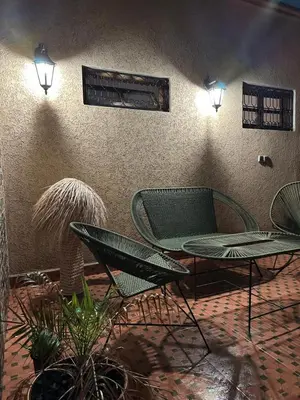 a patio with two chairs and a table and lights at Marrakech Airport in Marrakech