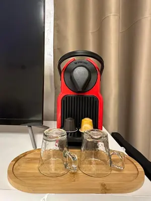 a coffee maker sitting on a table with two glasses at Marrakech Airport in Marrakech