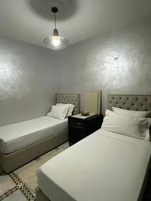 a bedroom with two beds and a lamp at Marrakech Airport in Marrakech