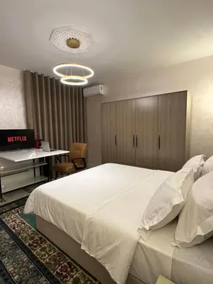 a bedroom with a large white bed and a desk at Marrakech Airport in Marrakech