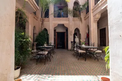 an empty courtyard with tables and chairs in a building at Palais Nejma - Locanda Boutique Collection in Marrakech