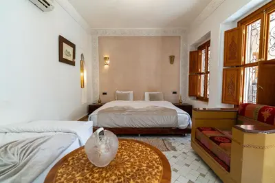 a hotel room with two beds and a table at Palais Nejma - Locanda Boutique Collection in Marrakech
