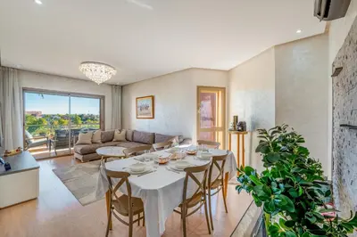 a living room with a table and a couch at Prestigia Opale - Superb condo with Golf & Pool views in Marrakech