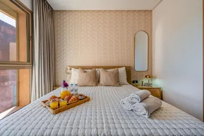 a bedroom with a bed with a tray of food on it at Prestigia Opale - Superb condo with Golf & Pool views in Marrakech