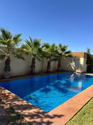 a swimming pool with palm trees next to a building at Bungalow in Marrakech in Marrakech