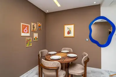 a dining room with a table and chairs and a mirror at Appartement Romantique et Moderne a Gueliz in Marrakech
