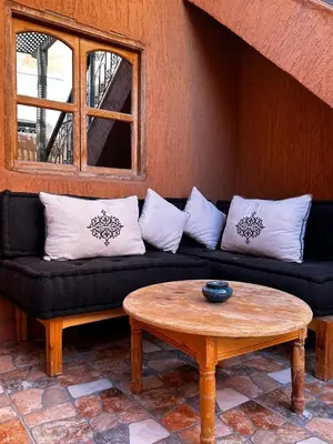 a black couch with white pillows and a coffee table at Riad Dar Kenza in Marrakech