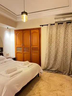 a bedroom with a bed and a wooden cabinet at Quiet & Central 1BR Apart with Pool in Gueliz in Marrakech