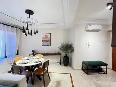 a dining room and living room with a table and chairs at Quiet & Central 1BR Apart with Pool in Gueliz in Marrakech