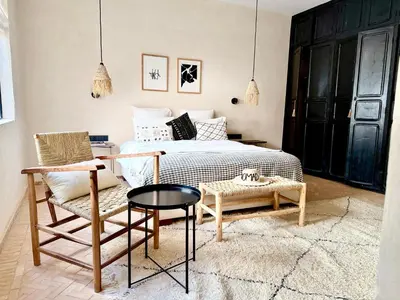 a bedroom with a bed and a chair and a table at Dar 43 with Private Pool Breakfast Included in Marrakech