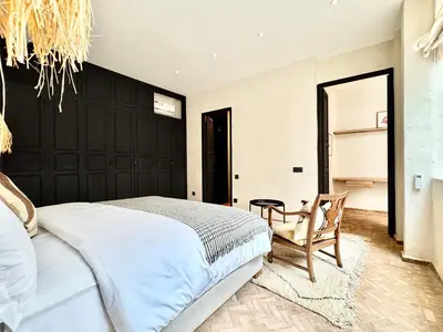 a bedroom with a large bed and a chair at Dar 43 with Private Pool Breakfast Included in Marrakech