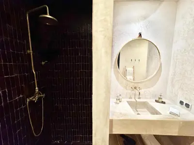 a bathroom with a sink and a mirror and a shower at Dar 43 with Private Pool Breakfast Included in Marrakech