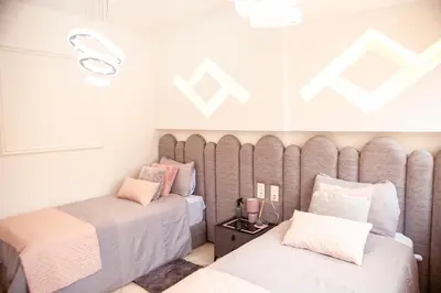 two beds in a small room with pink and white at Grand appartement Guéliz in Marrakech
