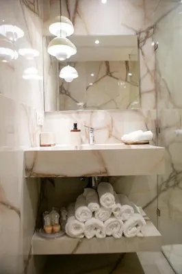 a bathroom with a sink and a pile of towels at Grand appartement Guéliz in Marrakech