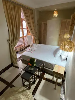 a bedroom with a large bed and a window at Riad Fontaine Arabe Privatisation in Marrakech