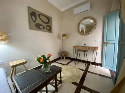 a living room with a table and a mirror at Riad Fontaine Arabe Privatisation in Marrakech