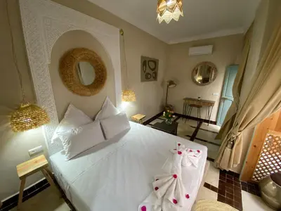 a bedroom with a white bed with white pillows at Riad Fontaine Arabe Privatisation in Marrakech